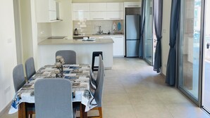 Una cocina moderna con armarios blancos, una isla central y un refrigerador integrado.