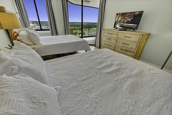 A hotel room with two beds, a dresser, a TV, and a balcony with a city view. - New,Top Floor Views,Private Maisons Sur Mer,Pools! (Myrtle Beach)