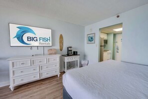 Quarto de hotel com uma cama, cômoda, cafeteira e um aviso para Big Fish Rentals.