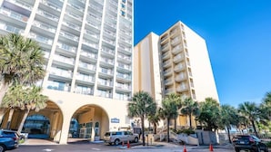 A hotel with a modern design, featuring a large entrance with an arched roof and multiple floors. - Nice Renovated Sea Mist with Amazing Ocean Views (Myrtle Beach)