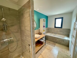 Enjoy a refreshing shower or soak in the bathtub in this bathroom.