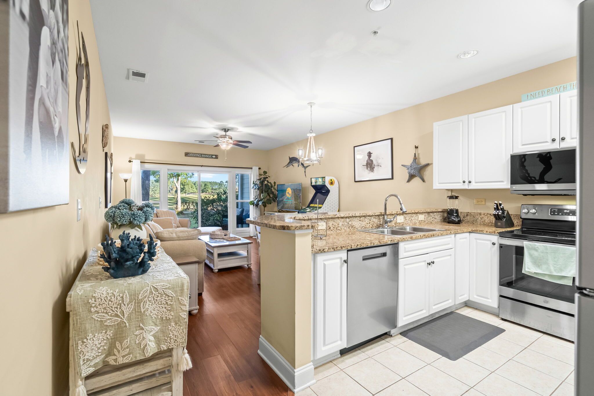 A modern kitchen with white cabinets, a granite countertop, and stainless steel appliances.