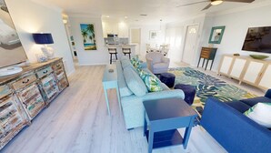A modern living room with a sofa, a coffee table, and a dining area with a table and chairs. - Crescent Arms Vacation Rentals Villa 2 Siesta Key Florida (Sarasota)