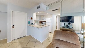 Eine moderne Wohnung mit Küche, Wohnbereich und Fernseher im Wohnzimmer.