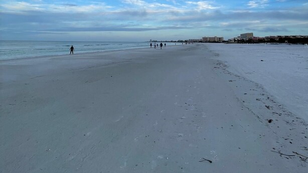 A wide sandy beach with a clear sky and a few people walking. - Crescent Arms Vacation Rentals 205N Siesta Key Florida (Siesta Key)