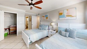 A bedroom with two beds, a ceiling fan, a bathroom, and a closet. - Crescent Arms Vacation Rentals 702 N Siesta Key Florida SEPTEMBER 25% off (Siesta Key)