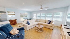 A living room with a sofa, coffee table, and a dining area with chairs and a table. - Crescent Arms Villa 10 Siesta Key Florida (Siesta Key)