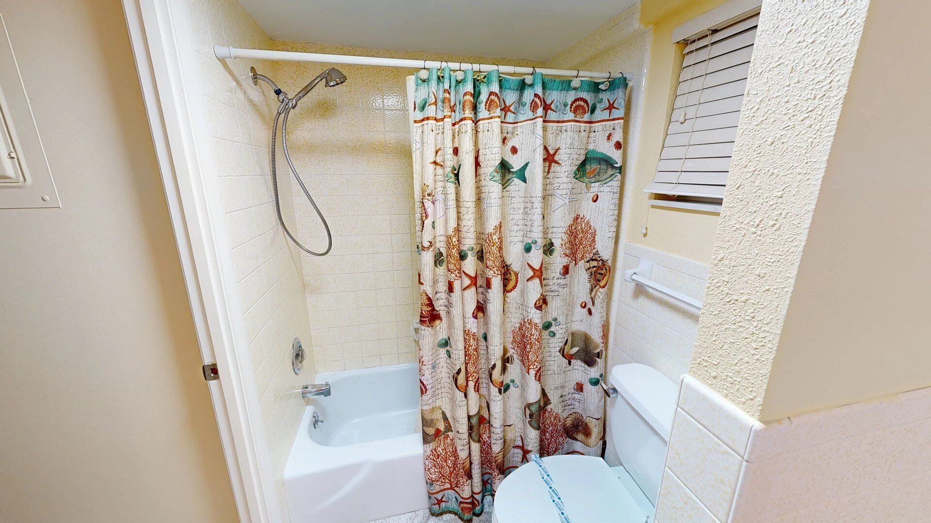 Un baño pequeño con bañera, inodoro y ducha.