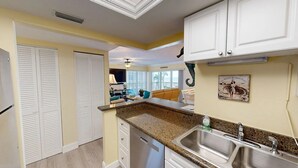 A kitchen with white cabinets, granite countertops, and stainless steel appliances. - Crescent Arms Vacation Rentals 204N Siesta Key Florida DISCOUNTS! (Siesta Key)