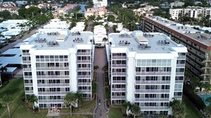 A high-rise hotel with multiple balconies, a rooftop pool area, and a beachside location. - Crescent Arms Vacation Rentals 405S Siesta Key Florida (Sarasota)