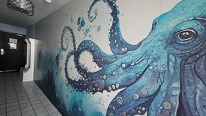A hallway with a mural of an octopus. - Octopus Garden: 1BR, King Bed, Indoor/Outdoor Pool (Carolina Beach)