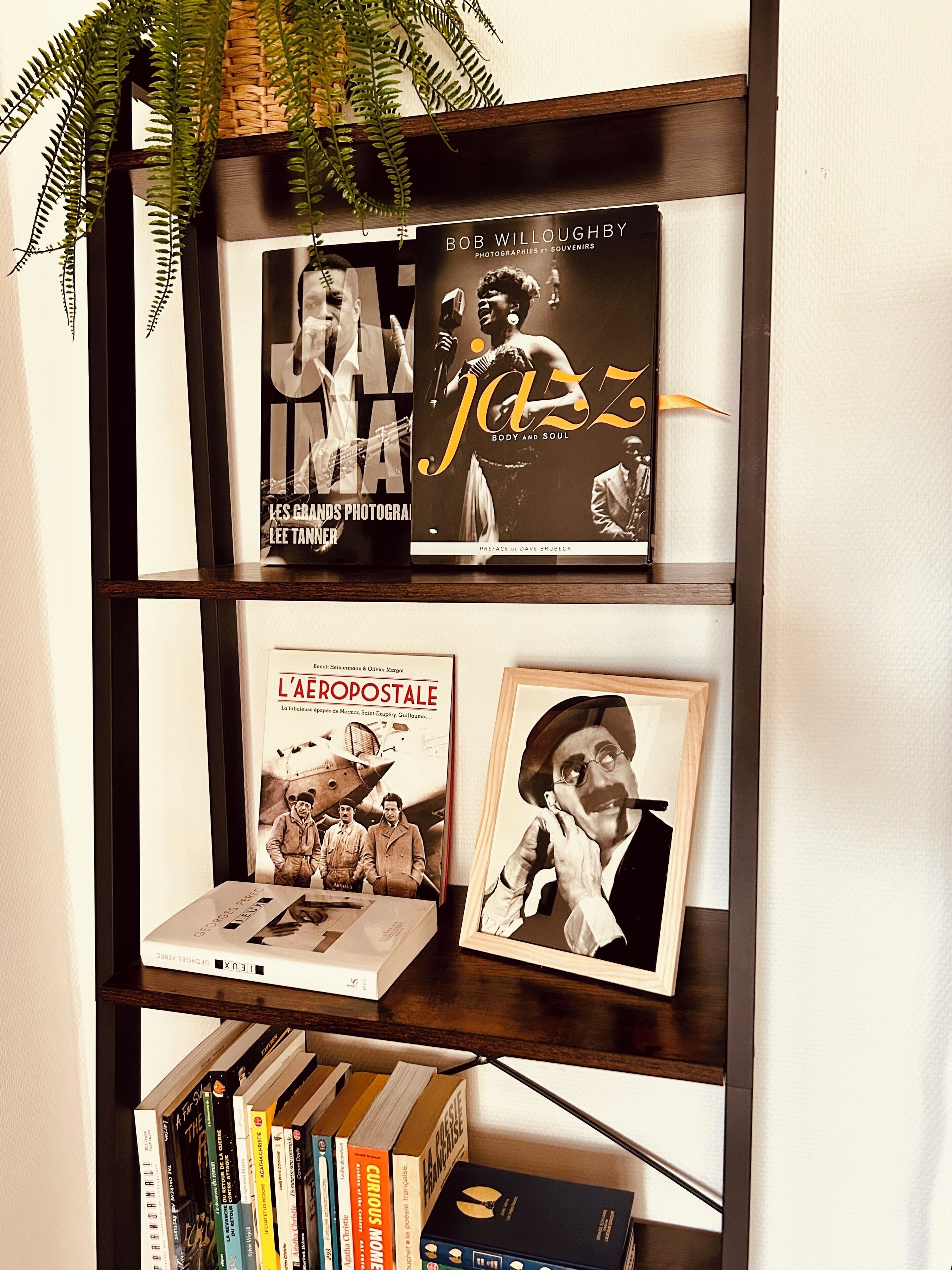 Een boekenplank met boeken en ingelijste foto's.