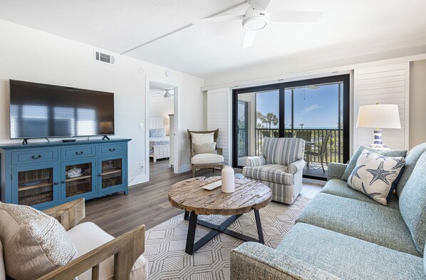 A living room with a TV, blue cabinet, round coffee table, and a sofa with star-patterned pillows.