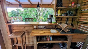 Una cocina rústica de madera con mostrador de madera, un lavabo y una ventana con vistas a la vegetación.
