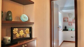 A hallway with a wooden cabinet, a clock, and a framed artwork. - The Painter's Nest + Lake Garden (Cima)