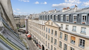 A row of historic buildings with uniform facades and multiple windows, typical of a European cityscape.
