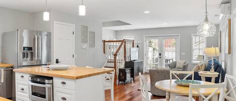 A modern kitchen with a central island, stainless steel appliances, and a dining area with a round table and chairs.