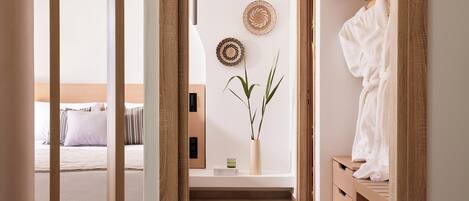 A bedroom with a bed, bedside table, and a hanging robe.