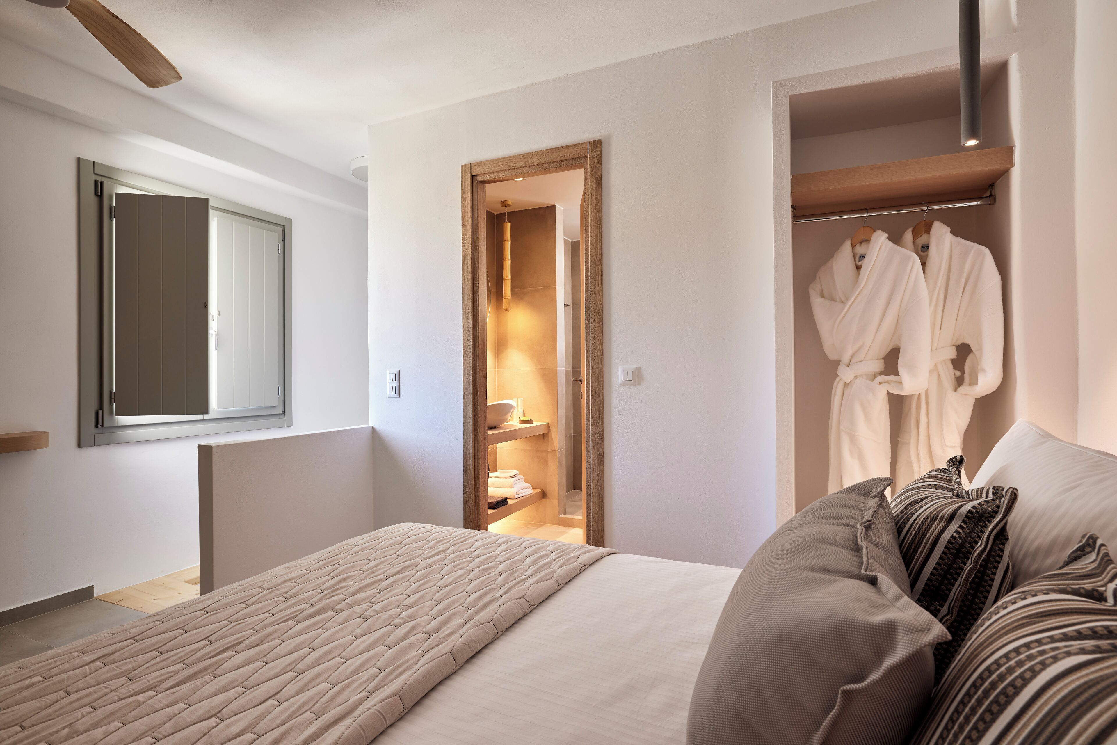 A bedroom with a bed, a wardrobe, and a walk-in closet.
