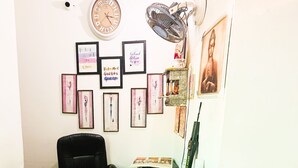 Un comptoir d’accueil agrémenté d’une horloge, de citations inspirantes encadrées et d’une statue de Bouddha.