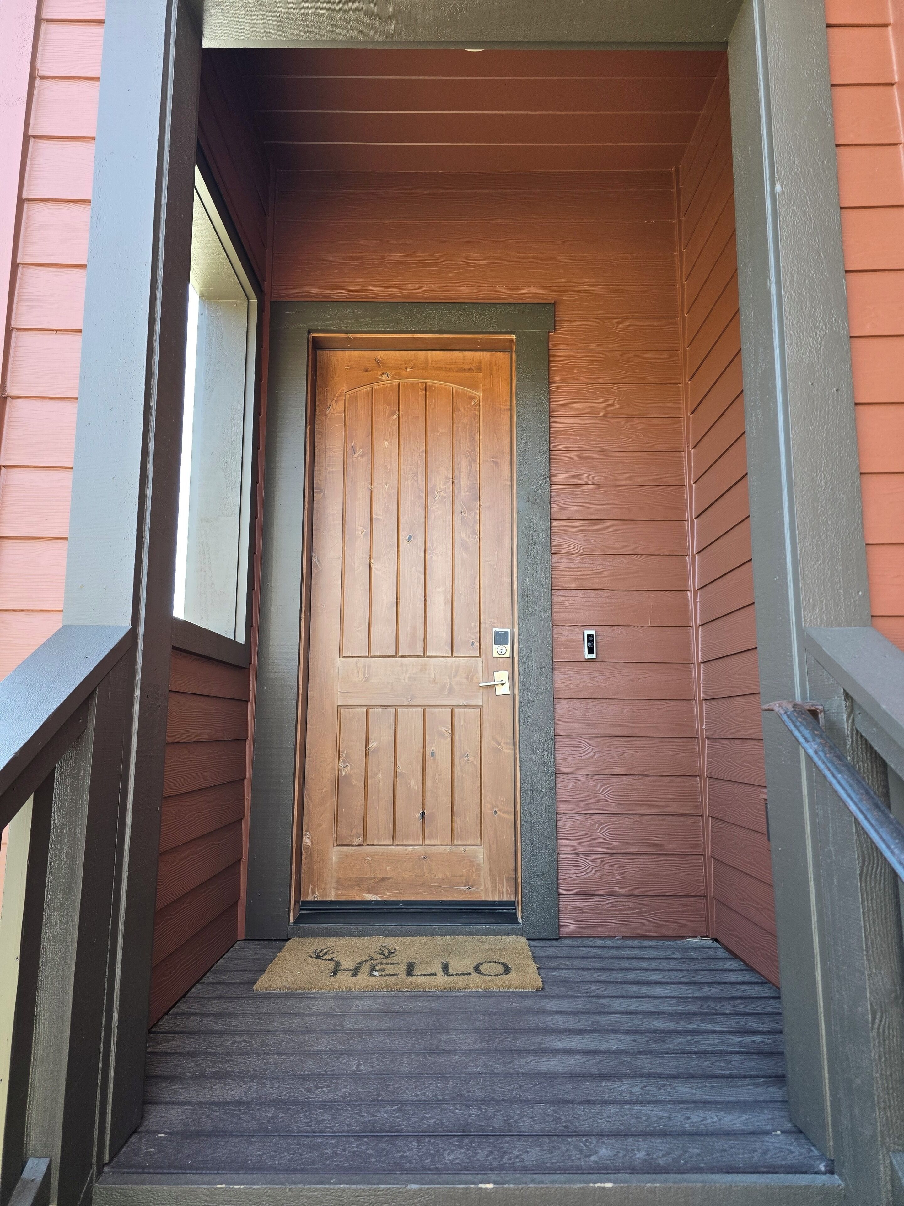 A wooden door with a doormat that reads 'HELLO'.