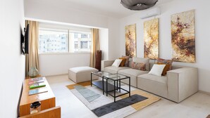 A modern living room with a sofa, a glass coffee table, and abstract art on the wall. - Charming apartment, in the heart of Agdal, 2 rooms (Rabat)