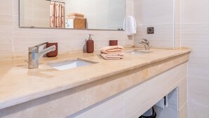 A modern bathroom with two sinks, a large mirror, and a towel rack. - Charming apartment, in the heart of Agdal, 2 rooms (Rabat)