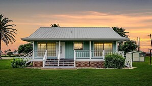 A single-story house with a porch, a small attached garage, and a well-maintained lawn.