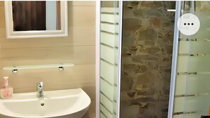 A bathroom with a white sink, a mirror, and a shower with a stone wall. - An oasis of tranquility near the beautiful beaches of Sarrabus. (Muravera)
