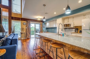 Una cocina moderna con barra, suelo de madera y una pared azul de acento.