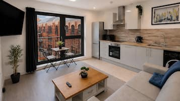 Un appartement moderne doté d’un balcon, d’une kitchenette et d’un canapé.