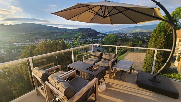 A balcony with outdoor furniture, a fire pit, and a view of the landscape.