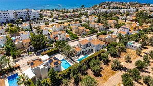 An aerial view of a coastal residential area with modern buildings, a swimming pool, and a clear view of the sea. - Villa Sophia by Ezoria Villas (Paphos)