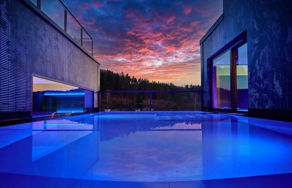 Piscine couverte, piscine extérieure, parasols de plage, chaises longues