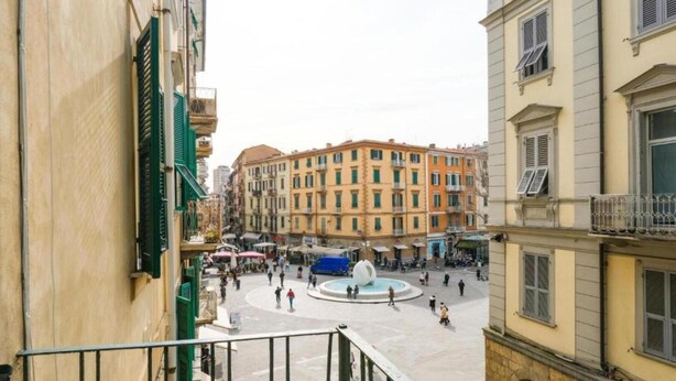 A public square with a fountain, surrounded by multi-story buildings with balconies. - Lia Rooms Cinque Terre Wave (La Spezia)