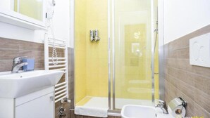A bathroom with a sink, bidet, and shower. - Lia Rooms Cinque Terre Wave (La Spezia)