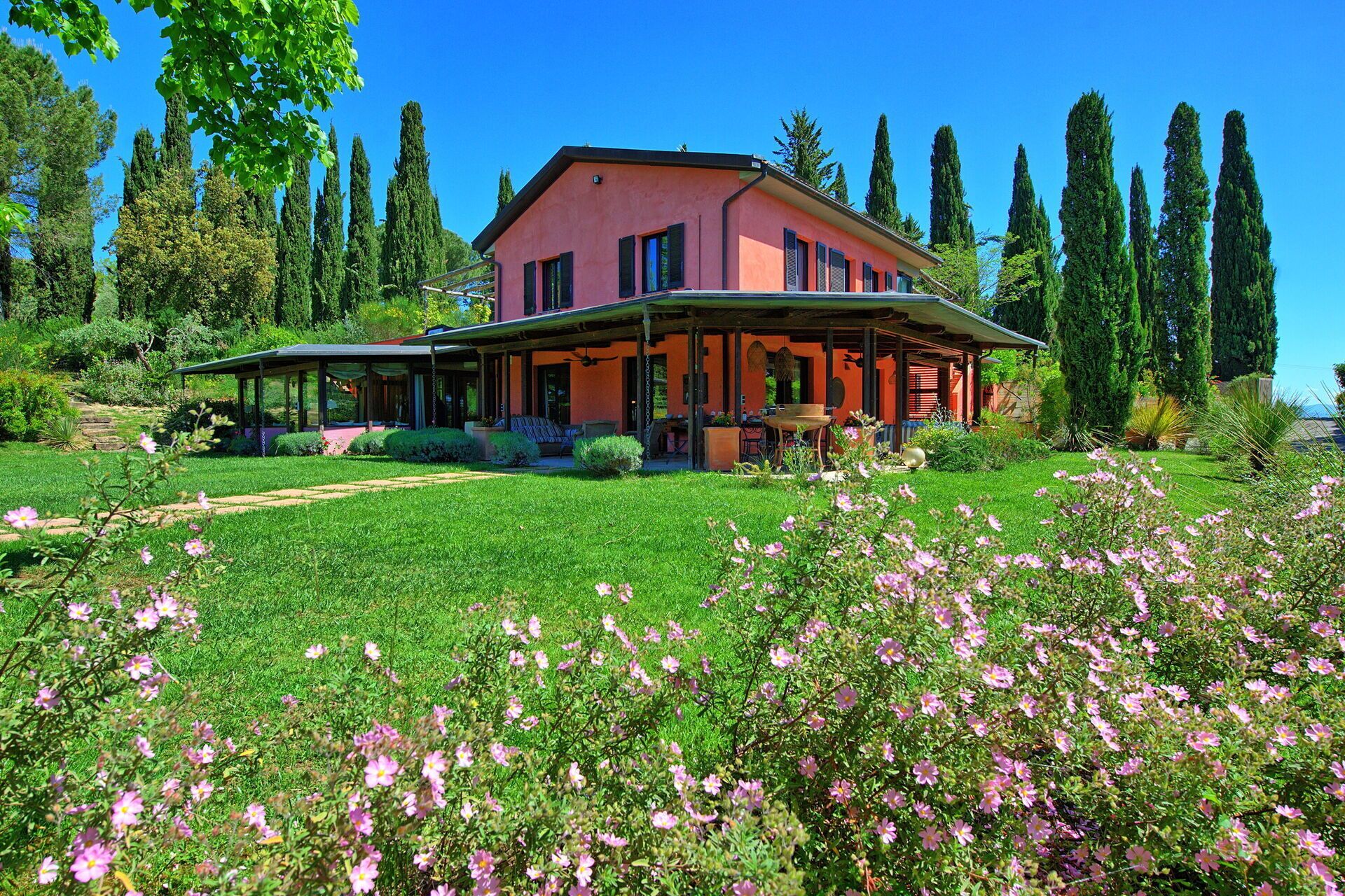 Une grande maison dotée d’un porche abrité et d’un jardin bien entretenu.