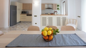 A modern kitchen with wooden cabinets, a built-in microwave, and a dining area with a table set for two.