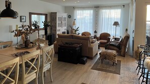 Ein geräumiges Wohnzimmer mit einem Holzesstisch, Sofas und einem großen Schrank.