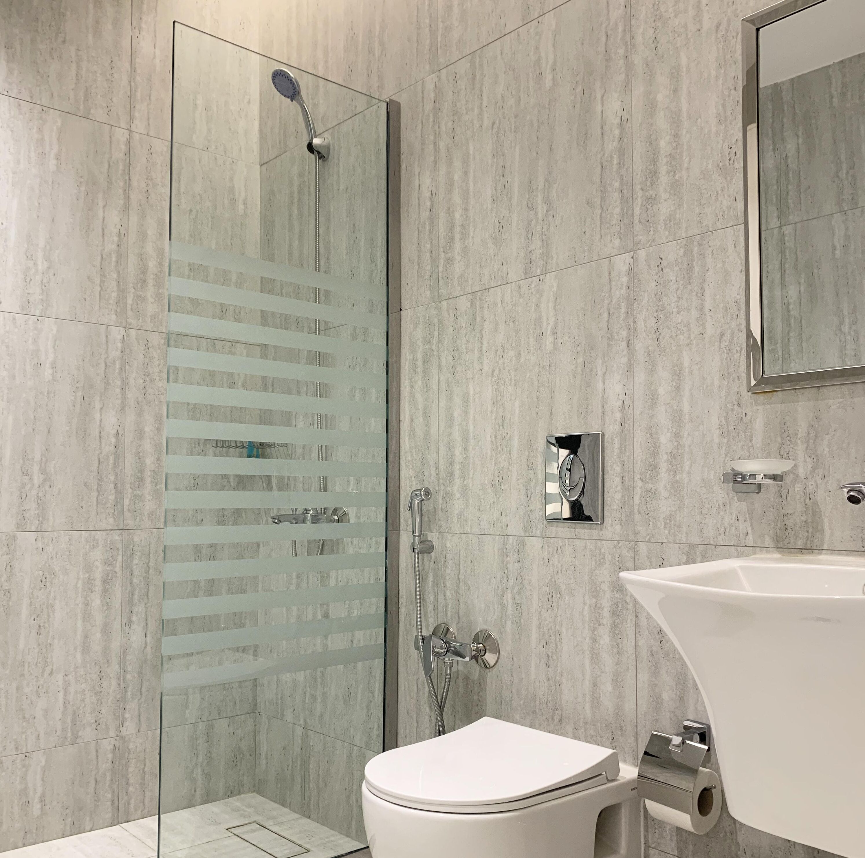 Une salle de bain moderne avec une douche à parois de verre, des toilettes et un lavabo.
