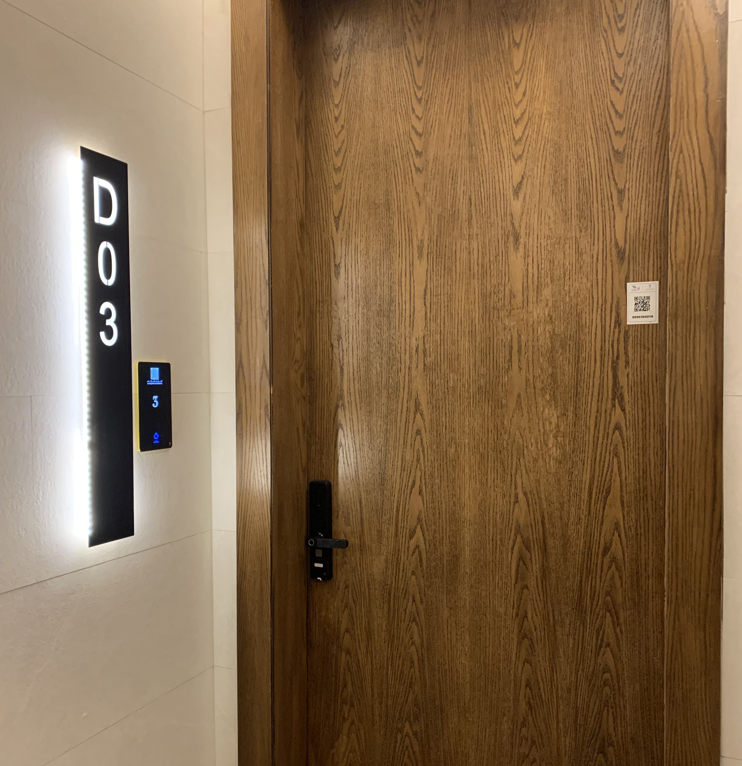 Puerta de madera con un panel digital que muestra el número de habitación D03.