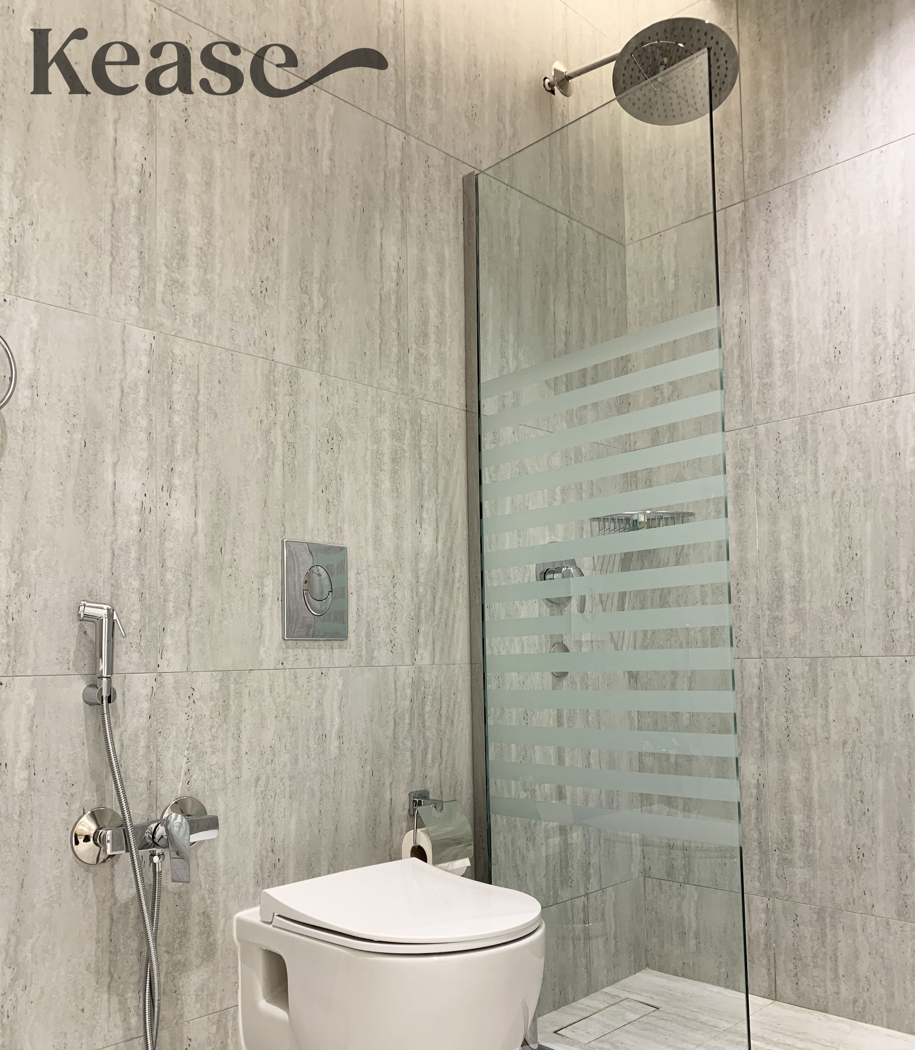 A modern bathroom with a toilet, shower, and glass-enclosed shower area.