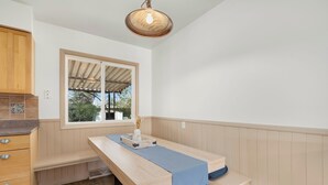 Ein helles, modernes Badezimmer mit einem Holzwaschtisch, einer Bank und einem Fenster, das natürliches Licht hereinlässt.