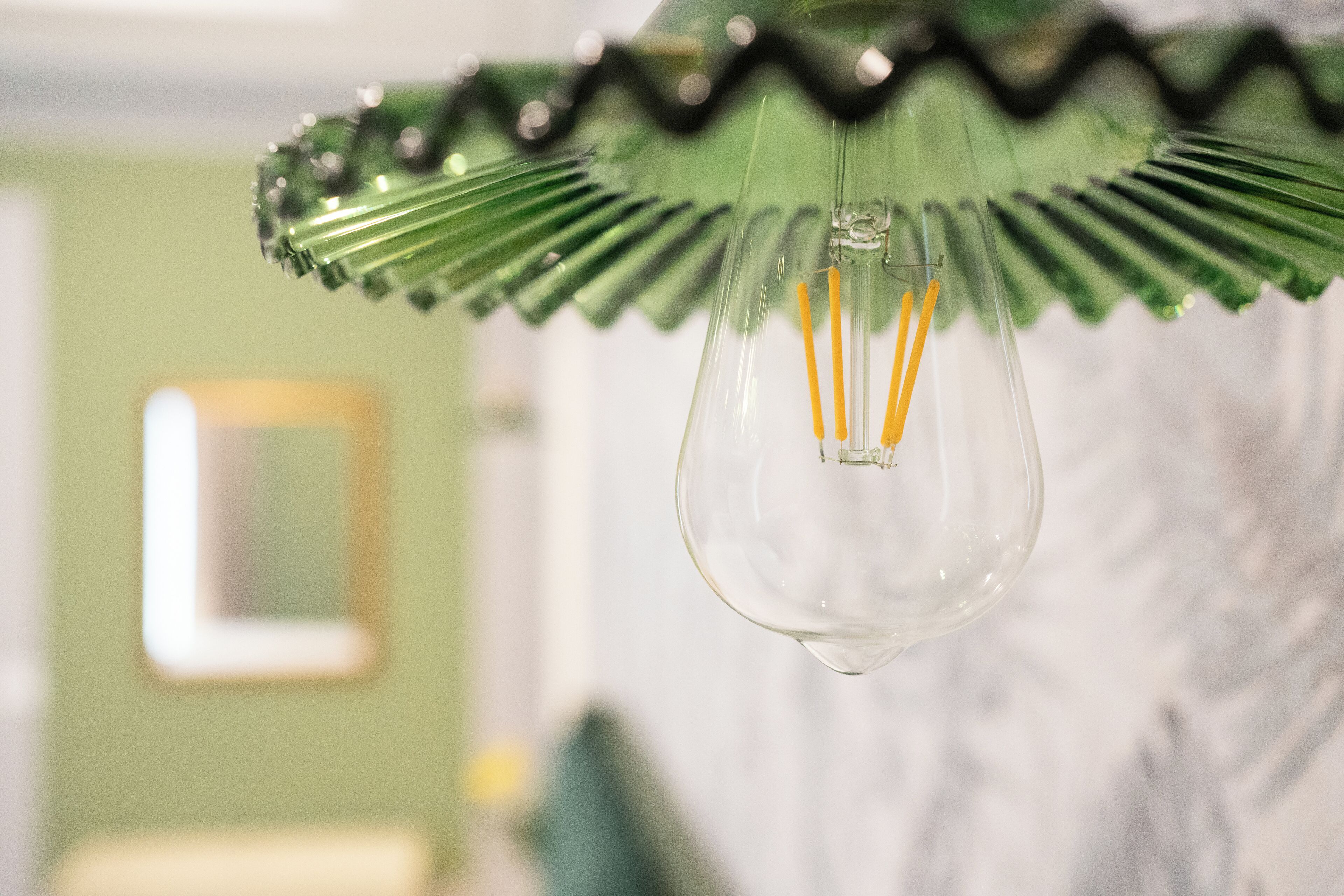Una lámpara de cristal transparente con un adorno verde.