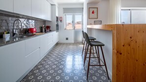 A modern kitchen with white cabinets, a red toaster, and a patterned floor. - Apt. dos Correios, a short walk to the town center (Lagos)