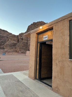 A reception area with a sign, a door, and a view of rocky terrain. - Star Wars Wadi Rum  (Wadi Rum)