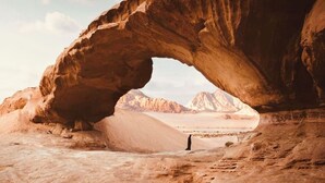 A natural rock arch formation with a person standing inside it. - Star Wars Wadi Rum  (Wadi Rum)