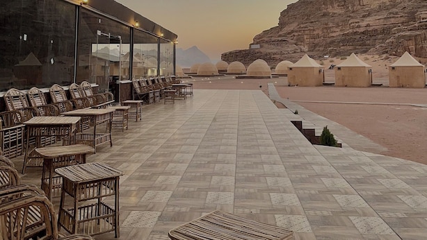 An outdoor seating area with wicker furniture and a view of a desert landscape. - Star Wars Wadi Rum  (Wadi Rum)