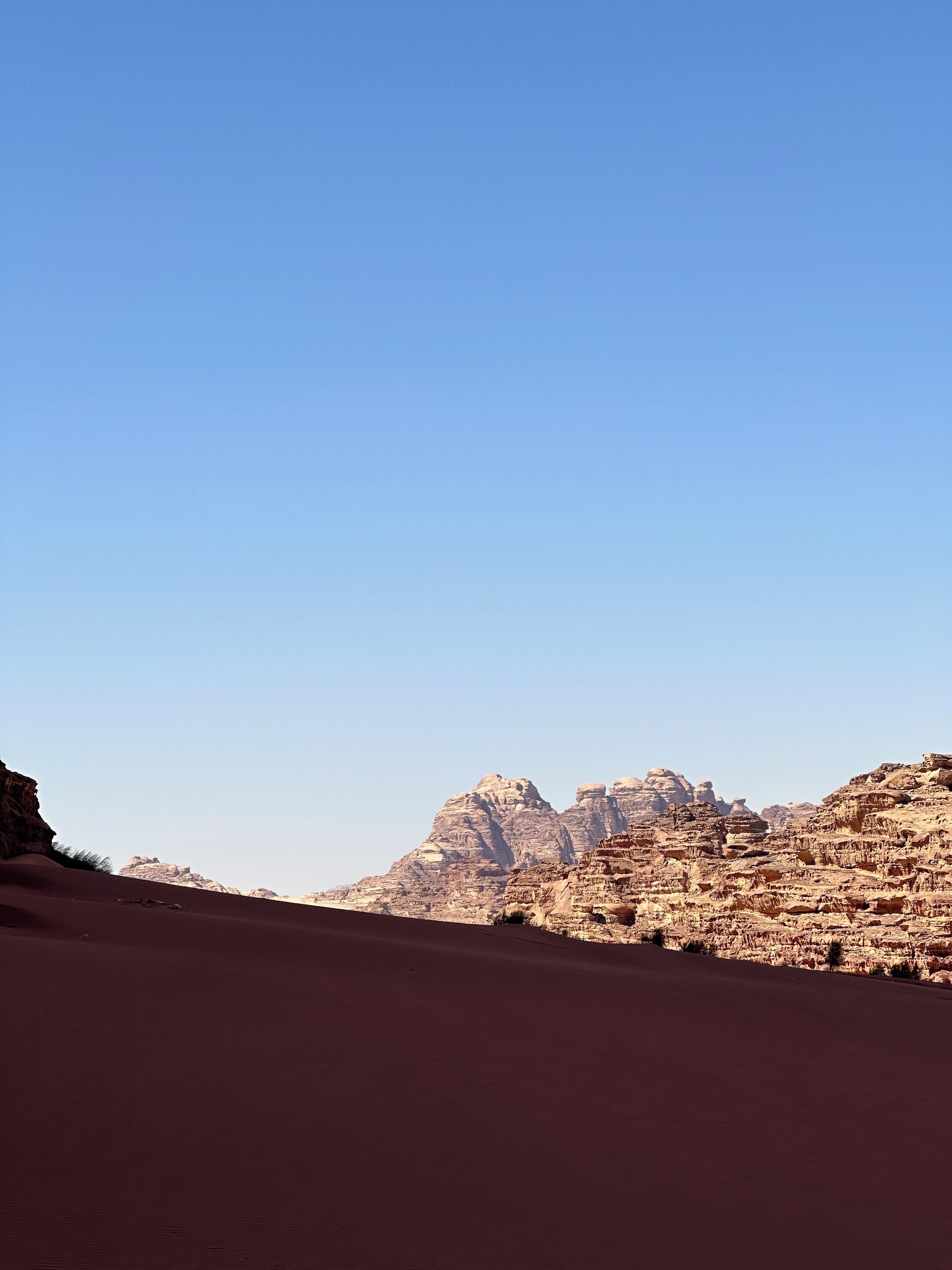 A desert landscape with prominent rock formations and a clear sky.