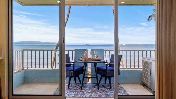 Ein Balkon mit Tisch für zwei Personen, mit Blick auf ein Gewässer.